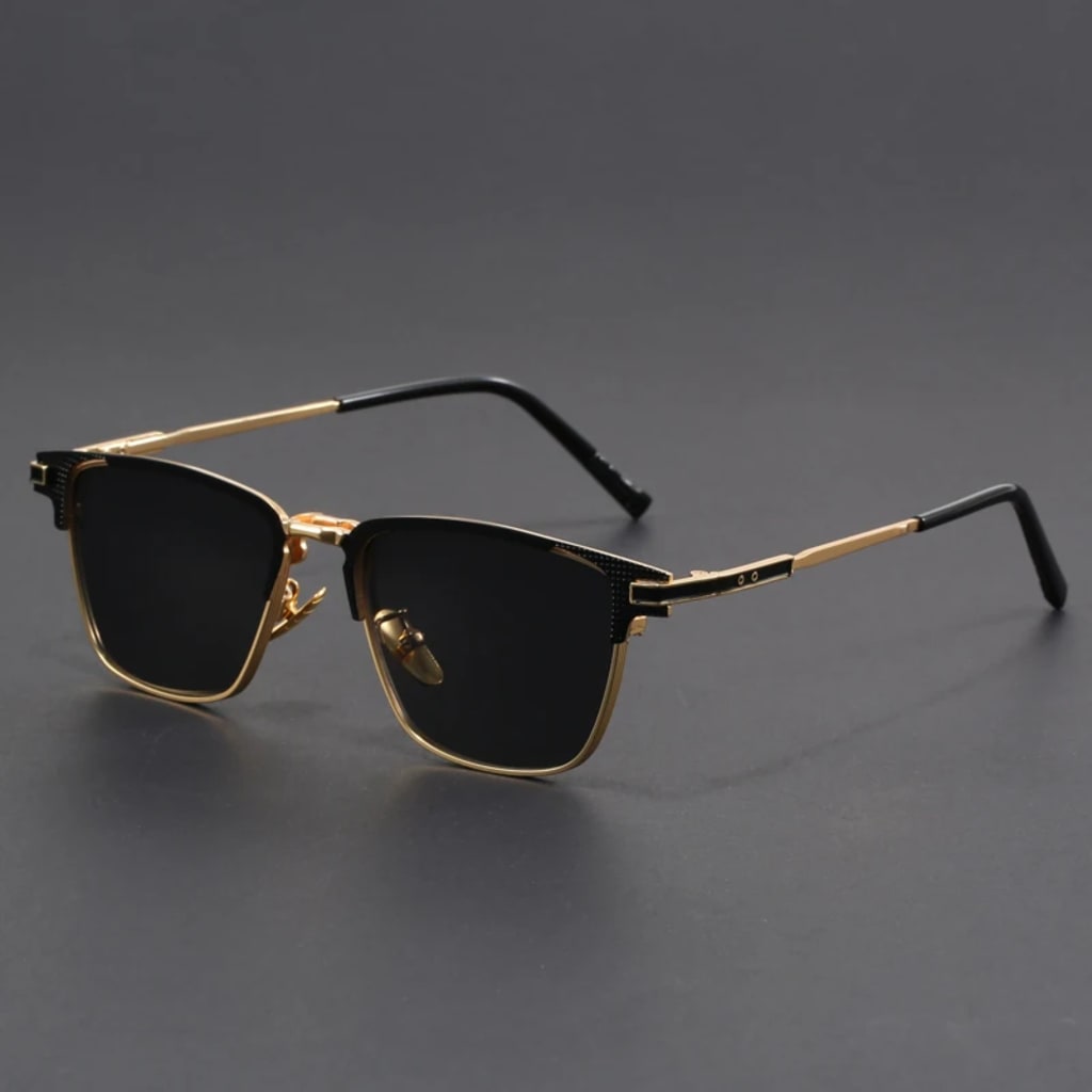 Sunglasses with gold frames and black lenses on a gray background